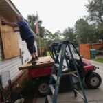 Dave McCurley boards up the windows to his home in advance of Tropical Storm Helene, expected to make landfall as a hurricane, in Ochlockonee Bay, Fla., Wednesday, Sept. 25, 2024.