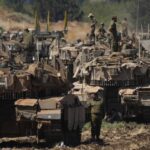 Israeli soldiers work on tanks in northern Israel on Friday, Sept. 27, 2024