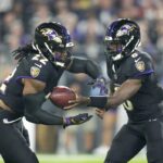 Baltimore Ravens running back Derrick Henry, left, takes a handoff from quarterback Lamar Jackson while running for a long touchdown against the Buffalo Bills during the first half of an NFL football game, Sunday, Sept. 29, 2024, in Baltimore.