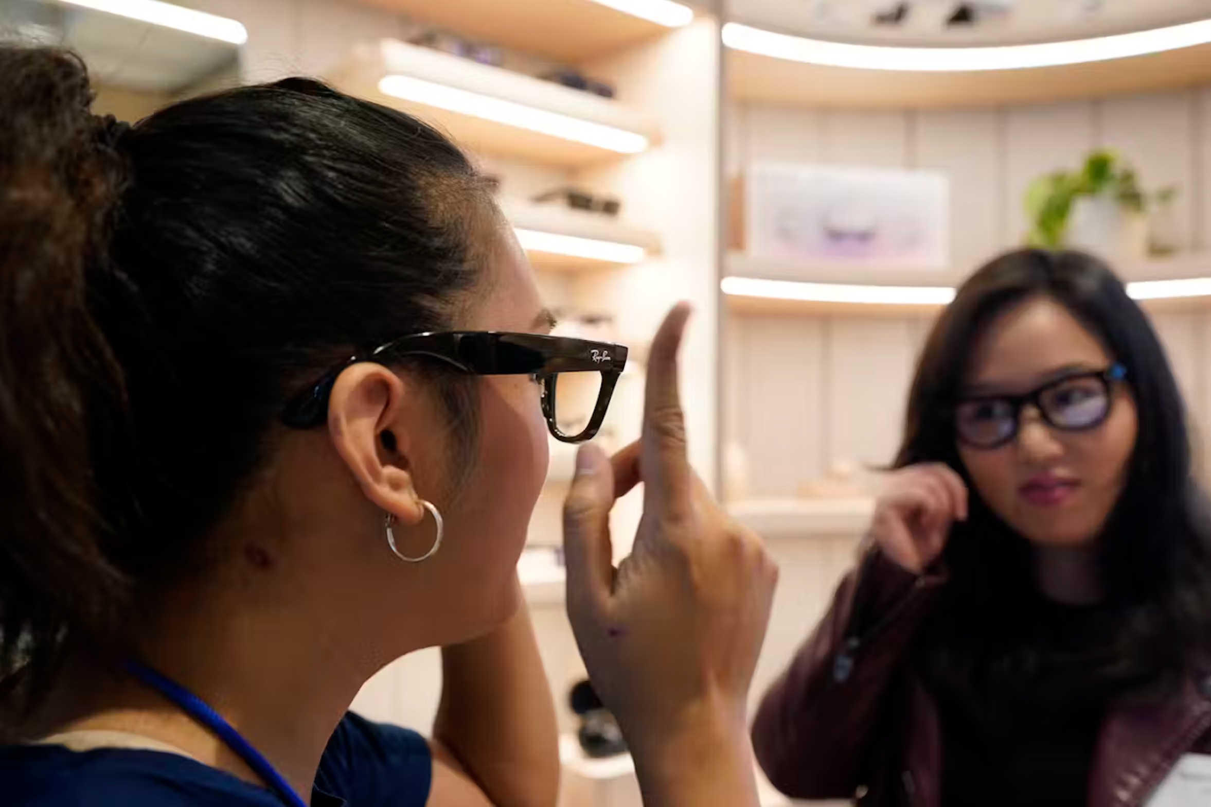 A Meta experience expert, left, demonstrates the Ray-Ban Stories smart glasses during a preview of the Meta Store in Burlingame, Calif., on May 4, 2022. (AP Photo/Eric Risberg)