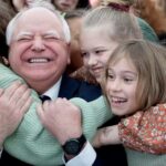 Minnesota Gov. Tim Walz gets hugs from students after signing into law a measure that guarantees free school meals at all of the state’s public and charter schools.