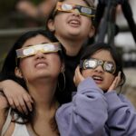 Viewers use special glasses to watch as the moon moves in front of the sun during an annular solar eclipse, or ring of fire, Saturday, Oct. 14, 2023, as seen from San Antonio.