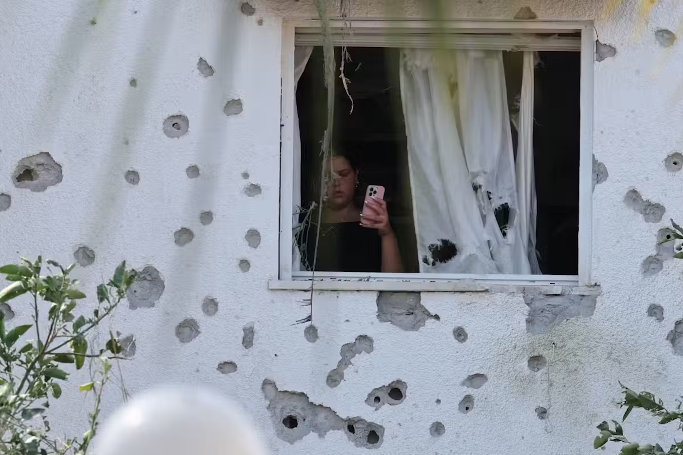 An Israeli woman inspects the damage of a Hezbollah missile strike on a residential neighbourhood in Kiryat Bialik, northern Israel. 