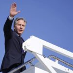 Secretary of State Antony Blinken waves as he boards a plane en route to the Middle East as he departs Joint Base Andrews, Md., Monday, Oct. 21, 2024.