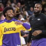 Los Angeles Lakers guard Bronny James, left, and forward LeBron James warm up before a preseason NBA basketball game against the Phoenix Suns, Sunday, Oct. 6, 2024, in Palm Desert, Calif.