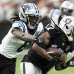 Las Vegas Raiders wide receiver Davante Adams is tackled by Carolina Panthers cornerback Jaycee Horn during the first half of an NFL football game, Sunday, Sept. 22, 2024, in Las Vegas.