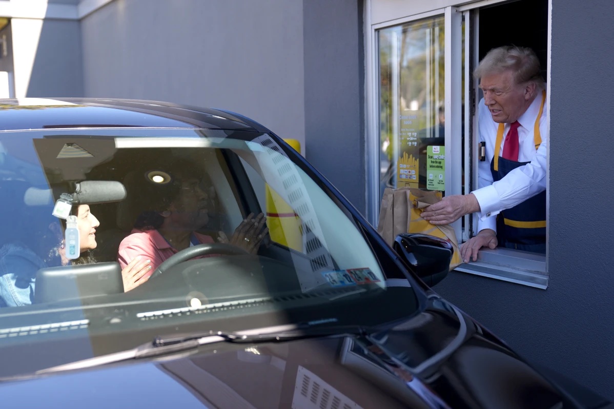 Republican presidential nominee former President Donald Trump hands an order to a customer at a drive-thru window during a campaign stop at a McDonald’s, Sunday, Oct. 20, 2024, in Feasterville-Trevose, Pa. 