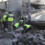 Rescue workers remove rubble, as they search for victims at the site that was hit by Israeli airstrikes in Qana village, south Lebanon, Wednesday, Oct. 16, 2024.