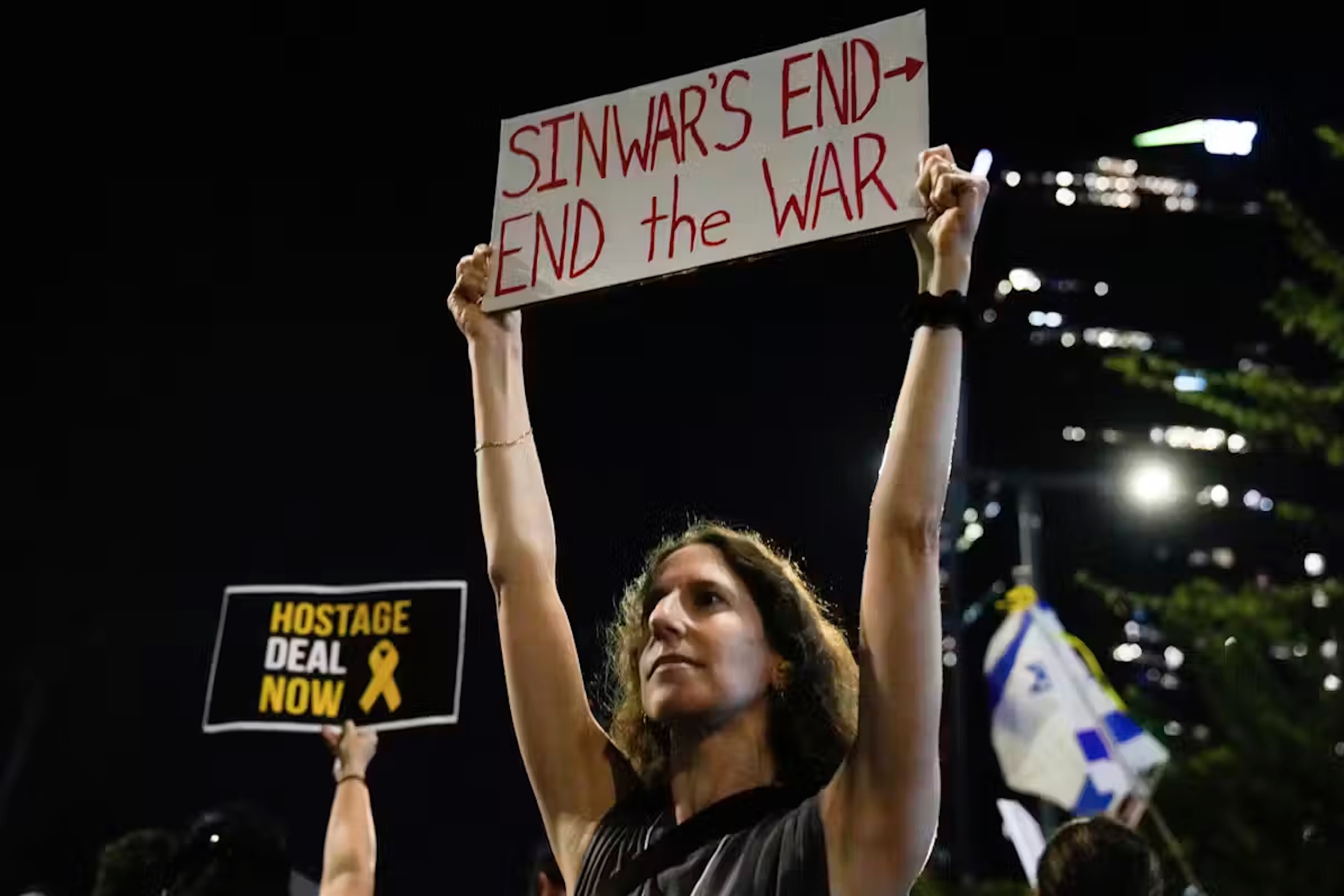 An Israeli demonstrator in Tel Aviv holds a sign calling for a ceasefire deal and the immediate release of hostages held by Hamas.