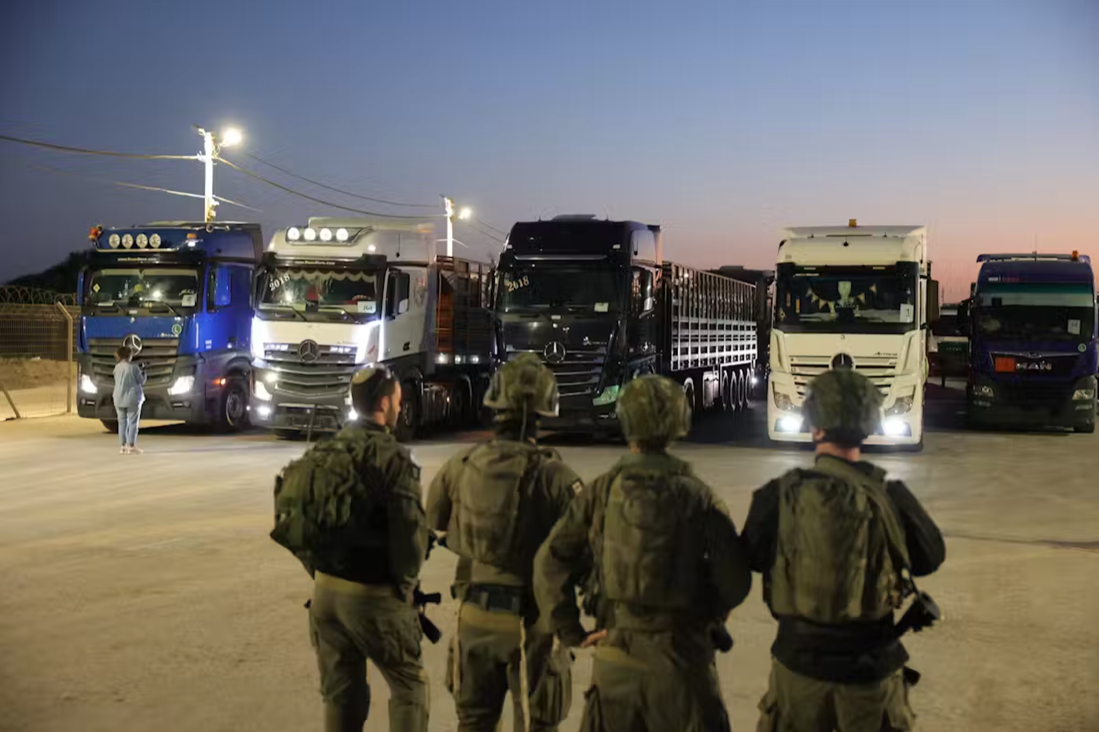 Israeli soldiers stand near aid trucks at the Erez crossing on the border with northern Gaza Strip on October 21. 