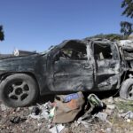 Journalists’ items on the ground next to a destroyed vehicle, at the site where an Israeli airstrike hit a compound housing journalists, killing three media staffers from two different news agencies according to Lebanon’s state-run National News Agency, in Hasbaya village, southeast Lebanon, Friday, Oct. 25, 2024.