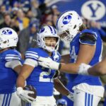 BYU running back LJ Martin, second from left, celebrates after scoring a touchdown in the second half of an NCAA college football game against Oklahoma State, Friday, Oct. 18, 2024, in Provo, Utah.