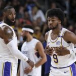 Los Angeles Lakers guard Bronny James (9), right, steps onto the court with Los Angeles Lakers forward LeBron James (23) during the first half of a preseason NBA basketball game Sunday, Oct. 6, 2024, in Palm Desert, Calif.