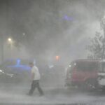 Max Watts, of Buford, Ga., walks in the parking lot to check on a trailer parked outside the hotel where he is riding out Hurricane Milton with coworkers, Wednesday, Oct. 9, 2024, in Tampa, Fla.