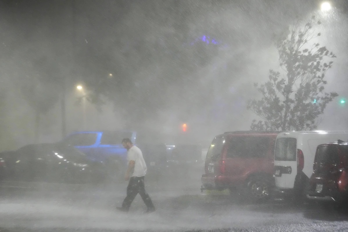 Max Watts, of Buford, Ga., walks in the parking lot to check on a trailer parked outside the hotel where he is riding out Hurricane Milton with coworkers, Wednesday, Oct. 9, 2024