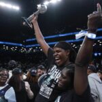 New York Liberty forward Jonquel Jones, left, holds up the MVP award after the Liberty defeated the Minnesota Lynx in Game 5 of the WNBA basketball final series, Sunday, Oct. 20, 2024, in New York.