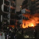 People gather in front of destroyed buildings hit by an Israeli airstrike in central Beirut, Lebanon, Thursday, Oct. 10, 2024.