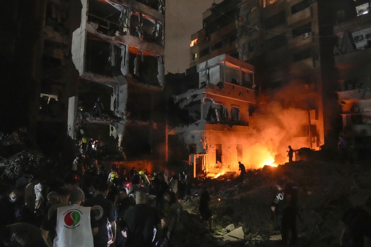 People gather in front of destroyed buildings hit by an Israeli airstrike in central Beirut, Lebanon, Thursday, Oct. 10, 2024.