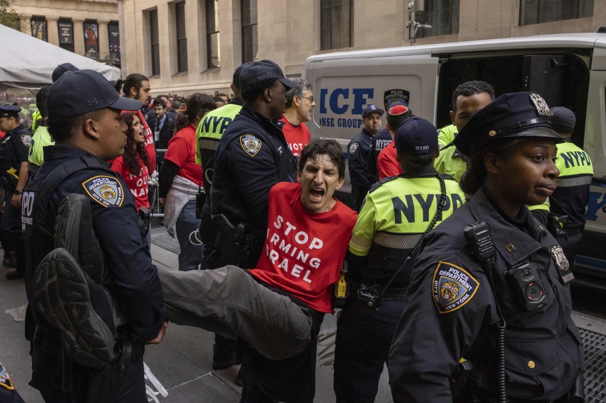 Police officers detain a demonstrator protesting Israel’s war against Hamas as they occupy an area outside the New York Stock Exchange, Monday, Oct. 14, 2024, in New York. 