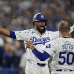 Los Angeles Dodgers’ Teoscar Hernández, left, gets sunflower seeds to the face to celebrate his solo home run as Mookie Betts (50) looks on during the seventh inning in Game 5 of a baseball NL Division Series against the San Diego Padres, Friday, Oct. 11, 2024, in Los Angeles.