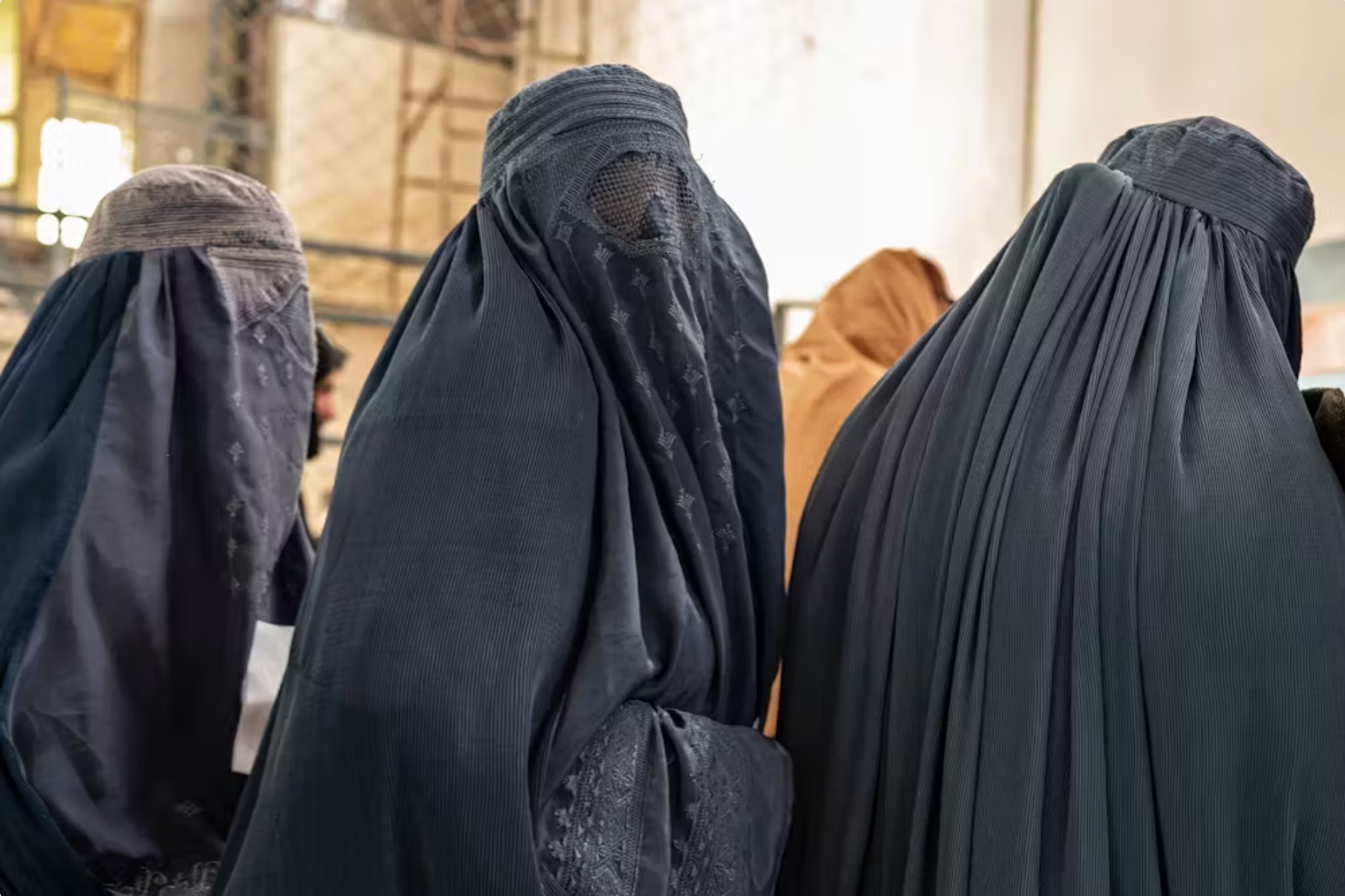 Women wait to receive food aid from a nongovernmental organization in Kabul on Jan. 17, 2023. 