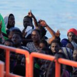 Several migrants wait to disembark from a wooden boat in the port of Arguineguin, on the island of Gran Canaria. Spain, October 20, 2024.