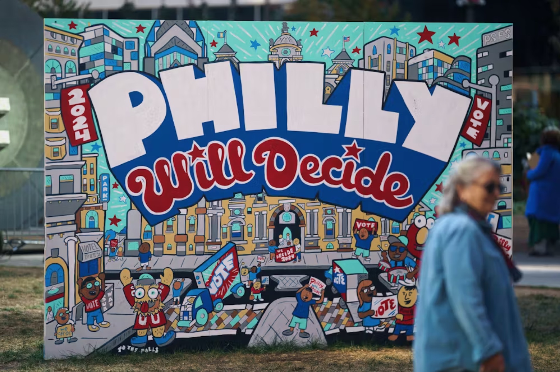 A woman passes signs encouraging early voting near Philadelphia City Hall in Philadelphia, Pennsylvania. 