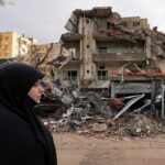 A woman walks past damaged buildings, in the aftermath of Israeli strikes on Beirut's southern suburbs, amid the ongoing hostilities between Hezbollah and Israeli forces, in Lebanon November 26, 2024.