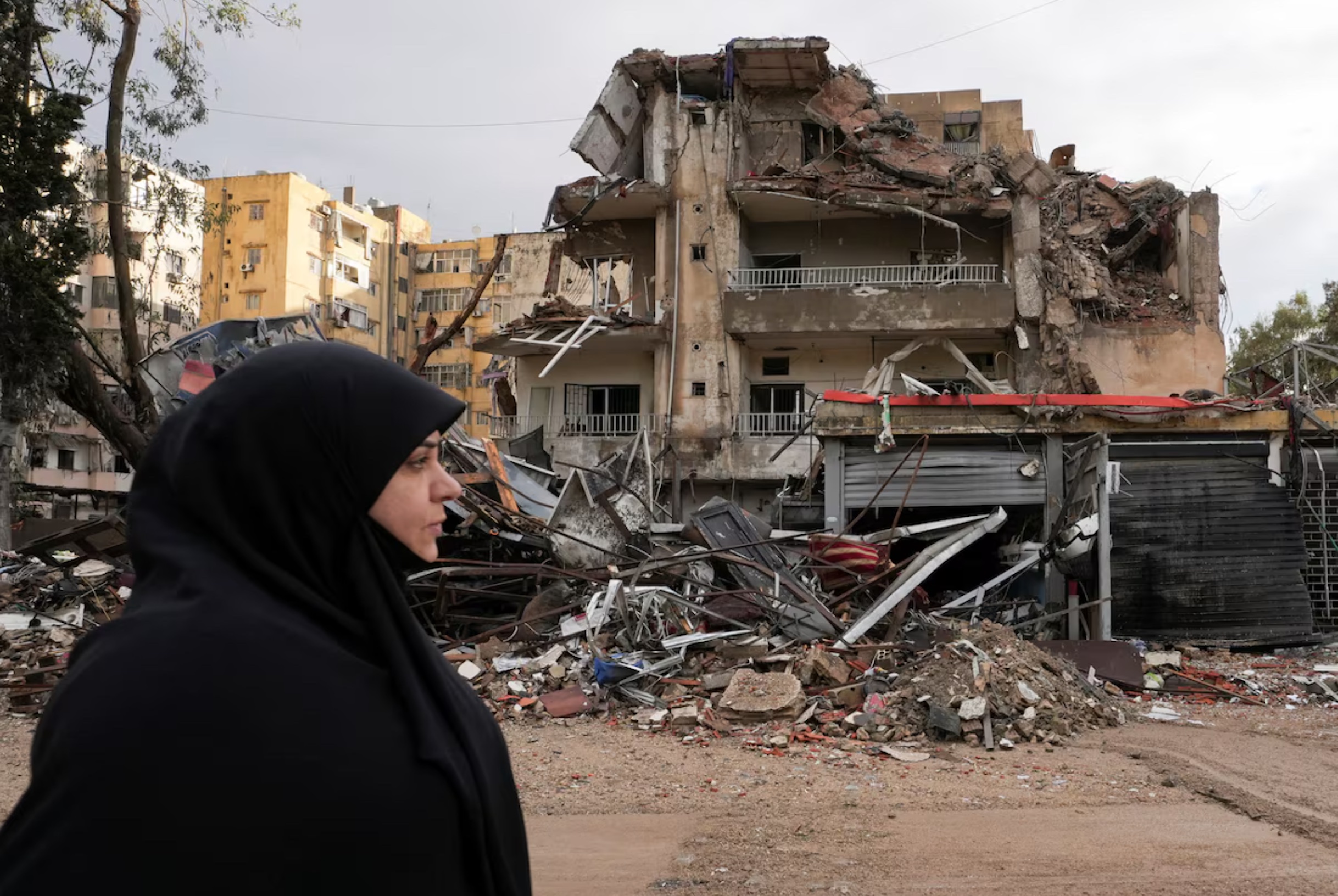 A woman walks past damaged buildings, in the aftermath of Israeli strikes on Beirut's southern suburbs, amid the ongoing hostilities between Hezbollah and Israeli forces, in Lebanon November 26, 2024. 