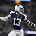 Dallas Cowboys linebacker DeMarvion Overshown (13) celebrates as he runs in for a touchdown on an interception against the New York Giants during the first half of an NFL football game in Arlington, Texas, Thursday, Nov. 28, 2024.