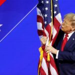 Donald Trump hugs an American flag as he arrives at the Conservative Political Action Conference on Feb. 24, 2024, in Baltimore.