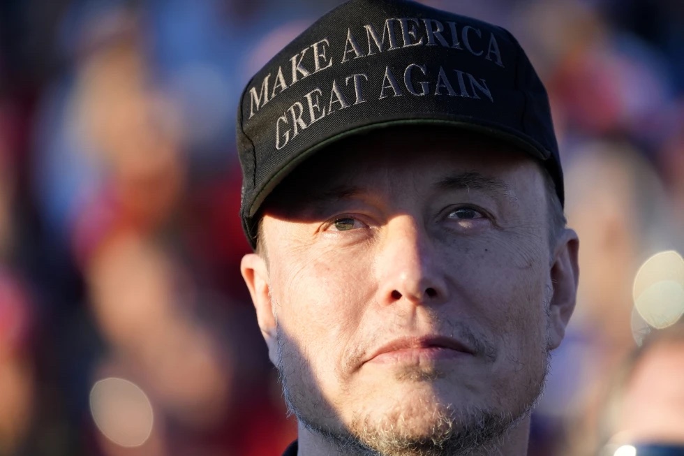 Tesla and SpaceX CEO Elon Musk listens as Republican presidential nominee former President Donald Trump speaks at a campaign event at the Butler Farm Show, Oct. 5, 2024, in Butler, Pa. 