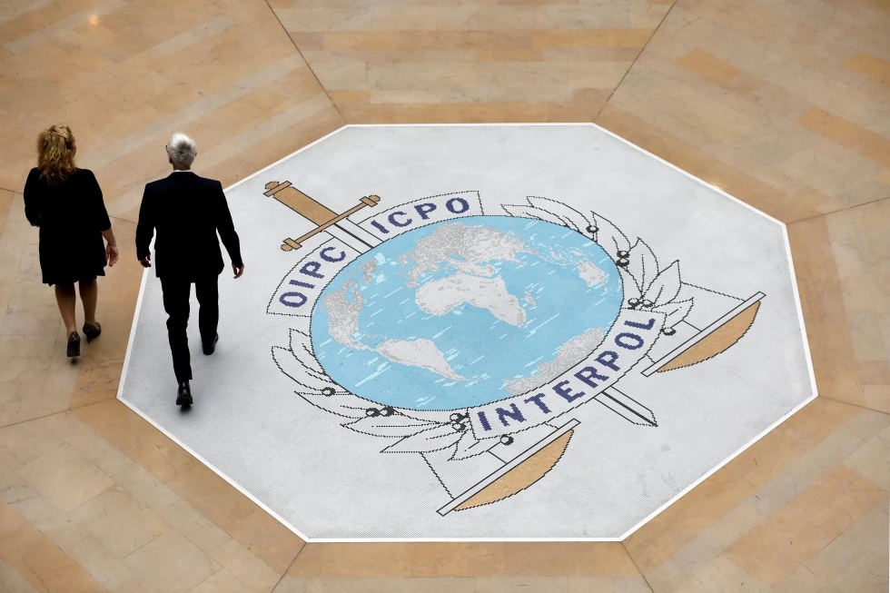 People walk on the Interpol logo at the international police agency headquarters in Lyon, France, on Nov. 8, 2018.