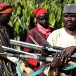 Members of the Yansakai vigilante group in north-west Nigeria surrendering their weapons, 2019.