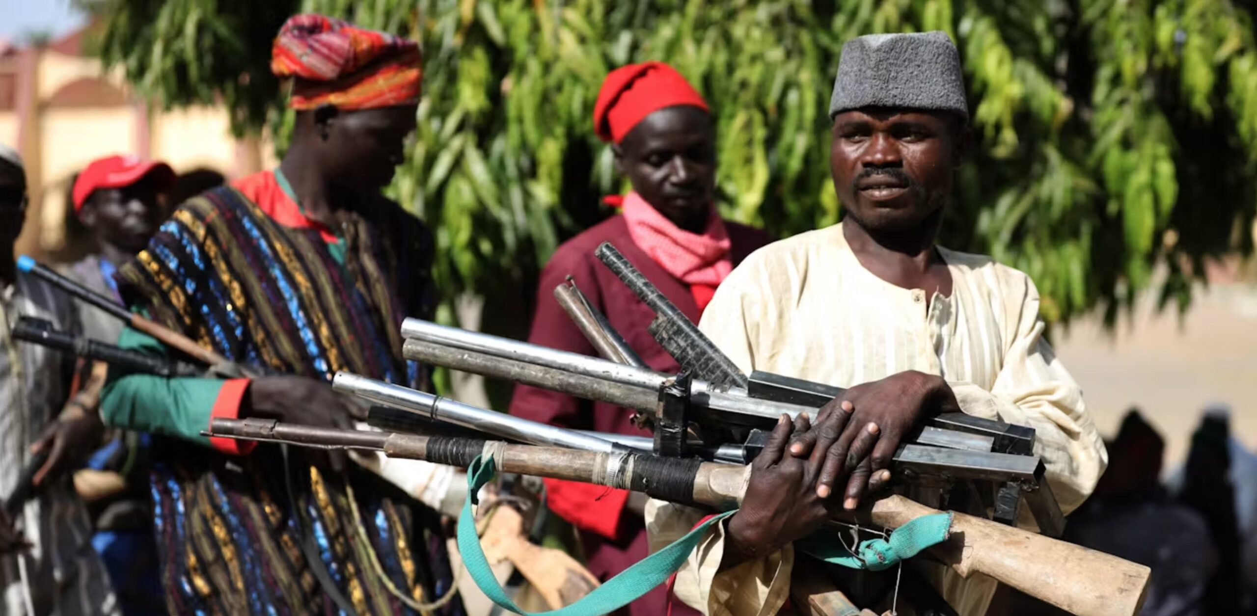 Members of the Yansakai vigilante group in north-west Nigeria surrendering their weapons, 2019. 