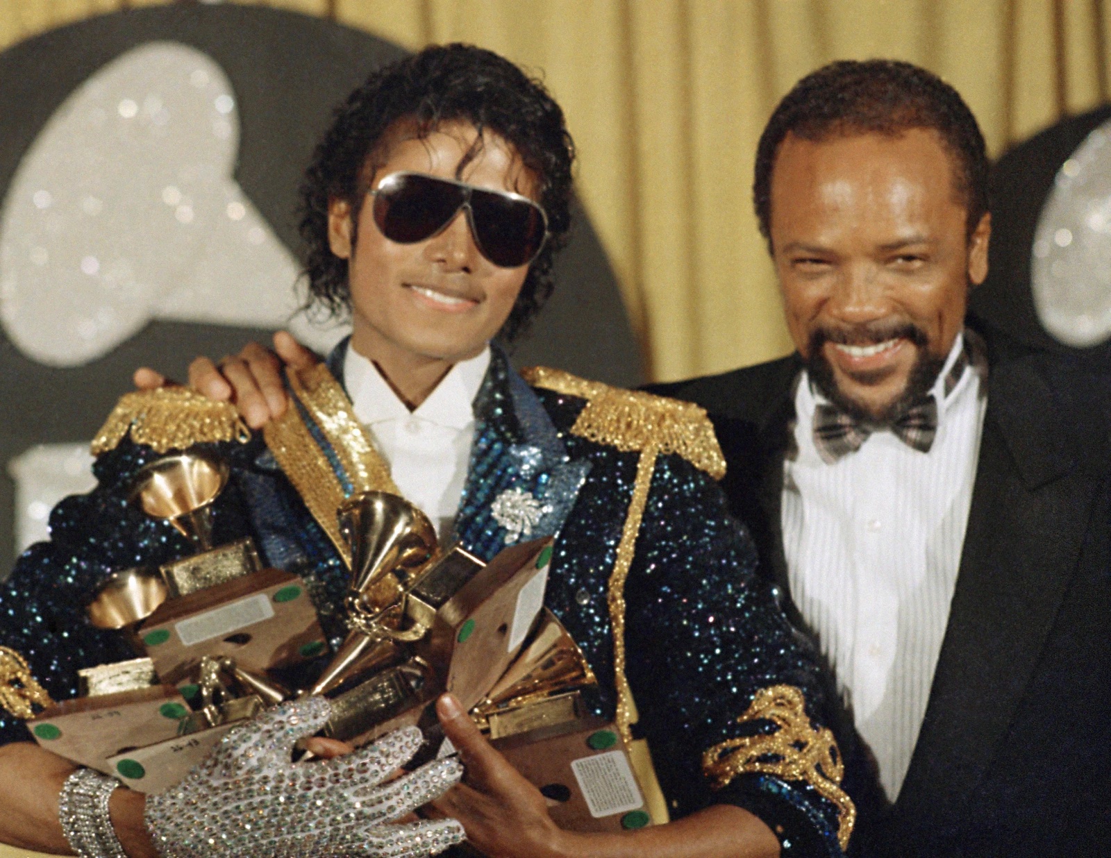 Michael Jackson, left, holds eight awards as he poses with Quincy Jones at the Grammy Awards in Los Angeles, Feb. 28, 1984. Quincy Jones died at age 91.