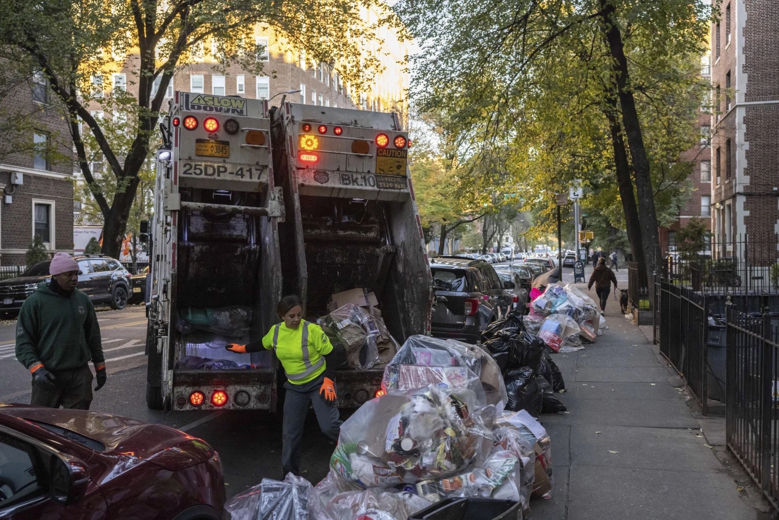 Sanitation workers collect trash, Saturday, Nov. 16, 2024, in the Brooklyn borough of New York. 