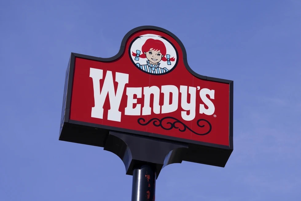 A sign for Wendy’s restaurant stands over one of its locations, Feb. 25, 2021, in Des Moines, Iowa. 