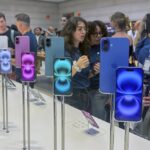 People gather near a display of iPhone 16’s at the Apple Store on 5th Ave. in New York on September 20, 2024.