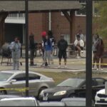 This image taken from video provided by WSFA shows people standing near the scene of an earlier shooting at Tuskegee University, Sunday, Nov. 10, 2024, in Tuskegee, Ala.