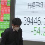 A person walks in front of an electronic stock board showing Japan’s Nikkei index at a securities firm Monday, Nov. 11, 2024, in Tokyo