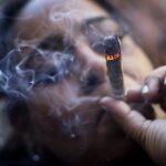 A person smokes cannabis outside the Smacked “pop up” cannabis dispensary location, Tuesday, Jan. 24, 2023, in New York.