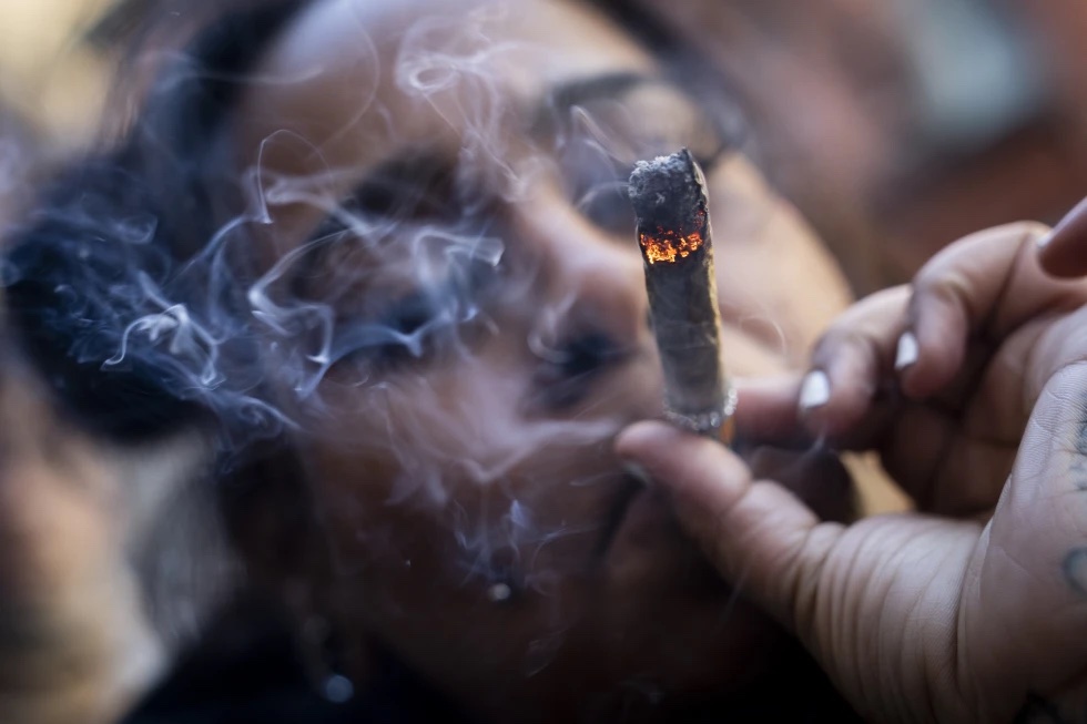 A person smokes cannabis outside the Smacked “pop up” cannabis dispensary location, Tuesday, Jan. 24, 2023, in New York.