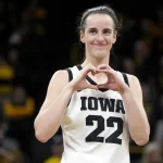 Iowa guard Caitlin Clark makes a heart gesture after the team’s NCAA college basketball game against Michigan, Thursday, Feb. 15, 2024, in Iowa City, Iowa. Clark broke the NCAA women’s career scoring record.