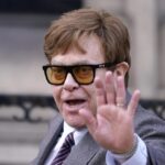 Elton John waves to the waiting media as he leaves the Royal Courts Of Justice in London, Monday, March 27, 2023.