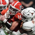 Texas linebacker Anthony Hill Jr. (0) hits Georgia quarterback Gunner Stockton (14) during the second half of the Southeastern Conference championship NCAA college football game, Saturday, Dec. 7, 2024, in Atlanta.