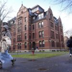 People walk between buildings, Tuesday, Dec. 17, 2024, on the campus of Harvard University in Cambridge, Mass.