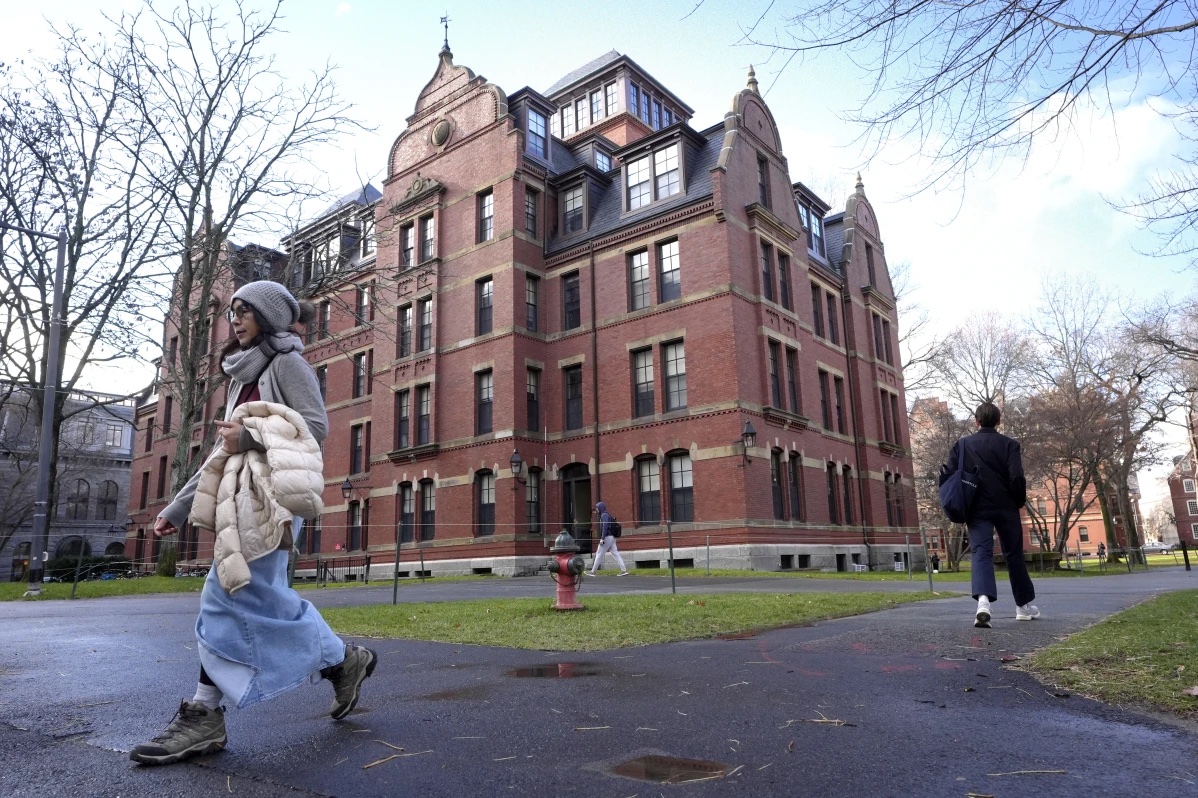 People walk between buildings, Tuesday, Dec. 17, 2024, on the campus of Harvard University in Cambridge, Mass. 