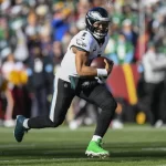 Philadelphia Eagles quarterback Jalen Hurts (1) running with the ball during the first half of an NFL football game against the Washington Commanders, Sunday, Dec. 22, 2024, in Landover, Md.