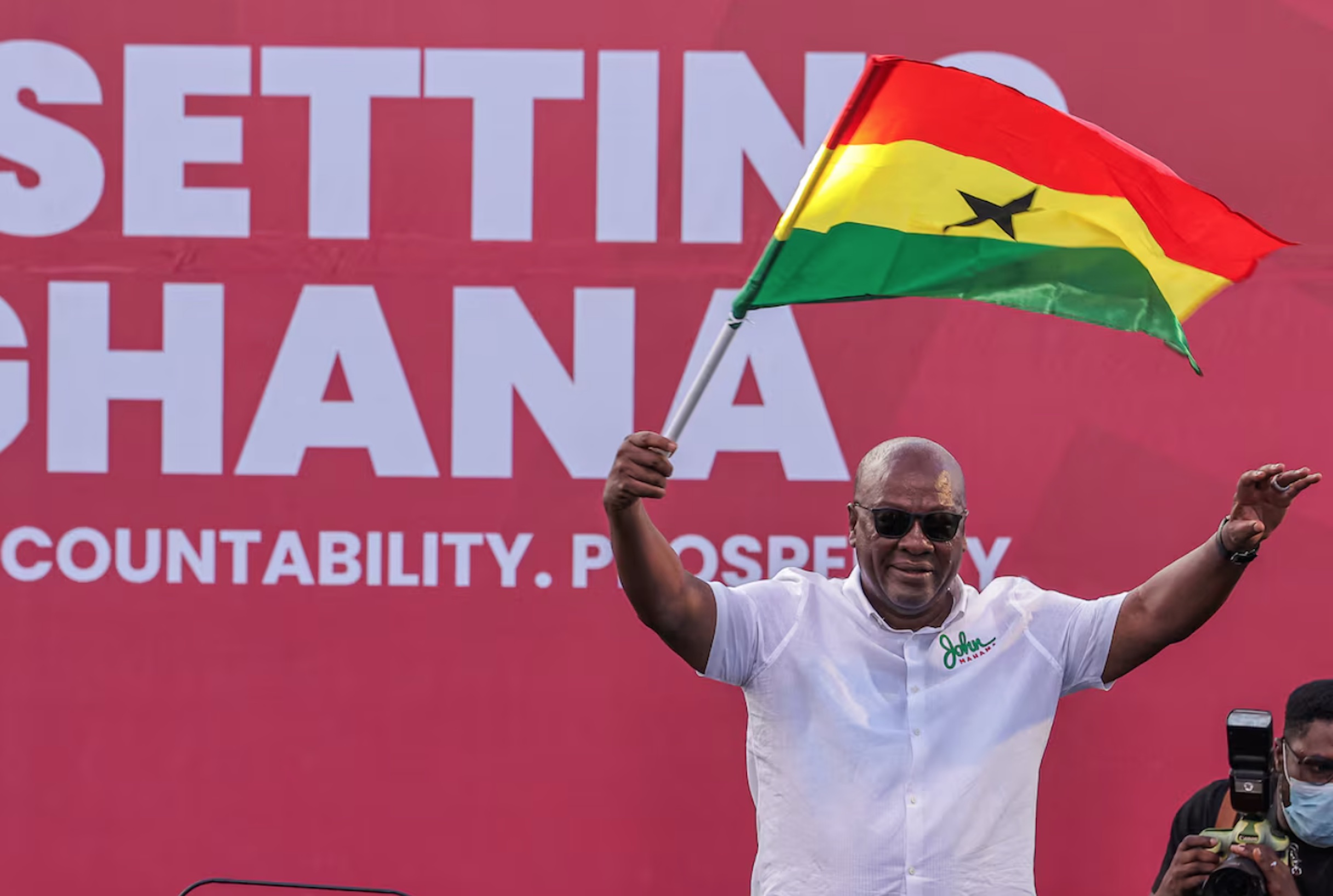 National Democratic Congress (NDC) presidential candidate and former Ghanaian President John Dramani Mahama holds a national flag as he waves to supporters during his final election campaign rally in Accra, Ghana December 5, 2024. 